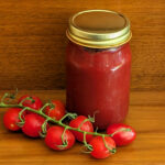sugar-free fermented ketchup in mason jar with on the vine ripe tomatoes