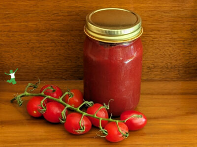 sugar-free fermented ketchup in mason jar with on the vine ripe tomatoes